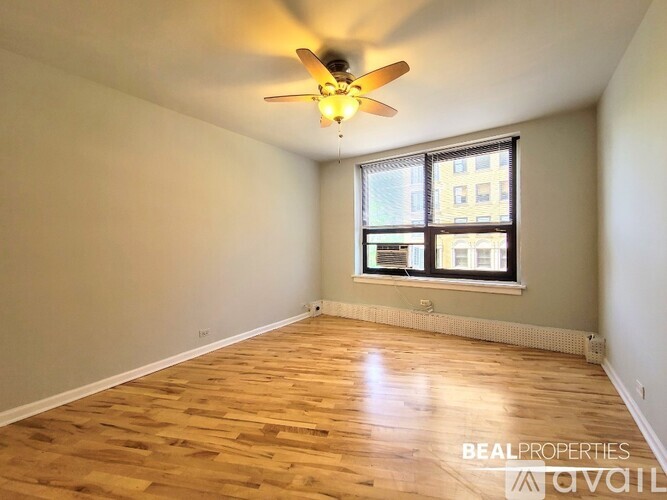 A room with a ceiling fan and wooden flooring.