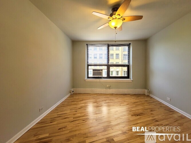 A room with wooden flooring and a ceiling fan with a light.