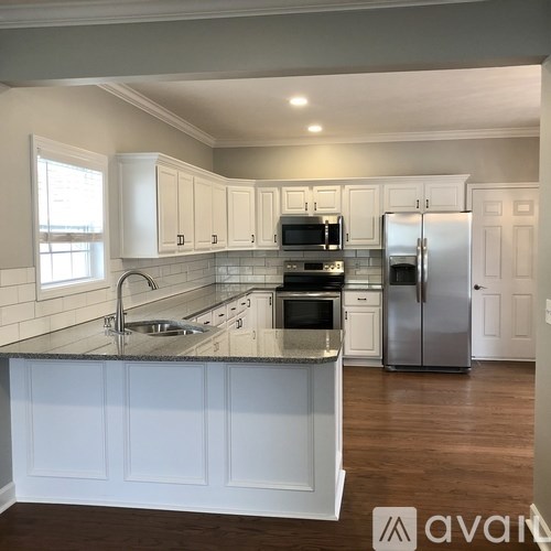 A kitchen with white cabinets and a granite countertop.