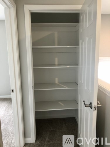 A white door with a handle and a sign that says "AVAIL" on the bottom right.