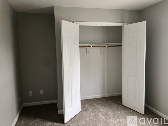 A room with a white door and a coat rack.