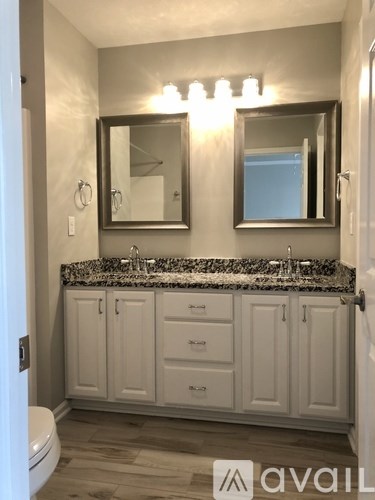 A bathroom with a granite countertop and white cabinets.