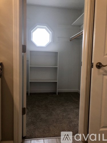 A room with a hexagonal window and a shelf.