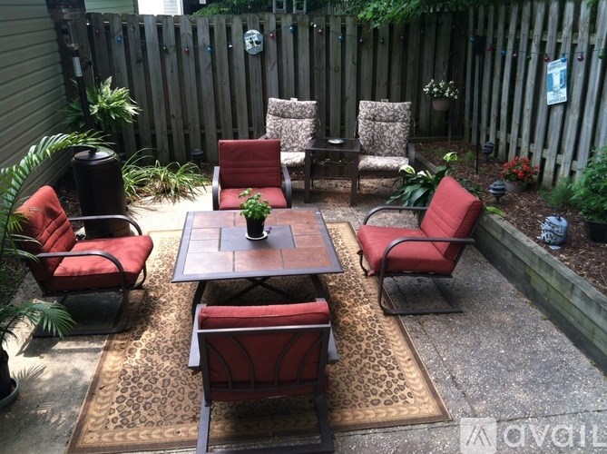 A patio with a table surrounded by chairs.