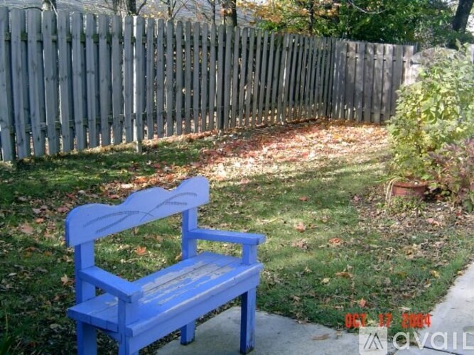 A blue bench sits in a yard.