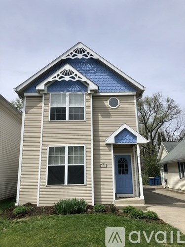A small house with a blue door and window trim.