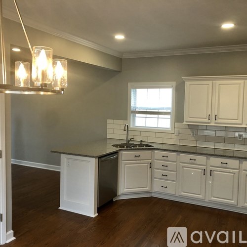 A kitchen with white cabinets and a darker countertop.