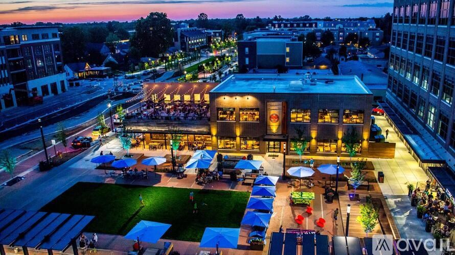 A rooftop bar with people sitting at tables under umbrellas.