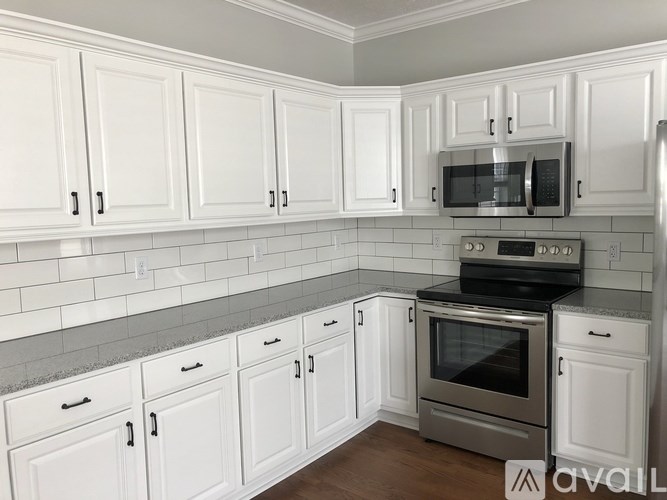 A kitchen with white cabinets and a stainless steel oven.