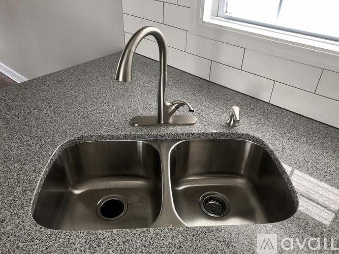 A modern double sink bathroom fixture with a chrome finish.