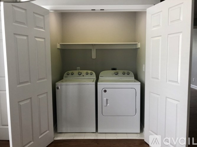 A small laundry room with a washer and dryer in it.