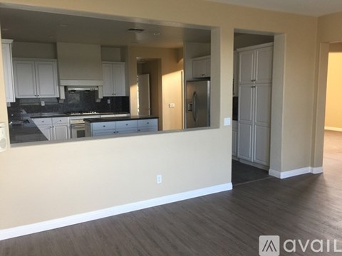 A kitchen with white cabinets and a black countertop.