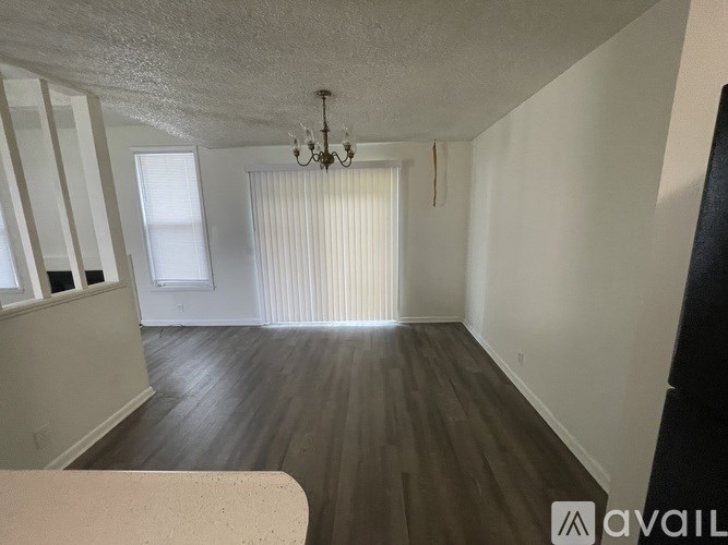 A room with wooden floors and a chandelier.