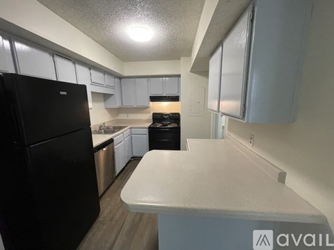A kitchen with black appliances and white cabinets.