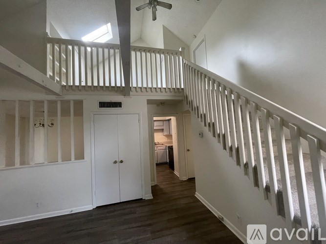 A room with a staircase and a door leading to another room.