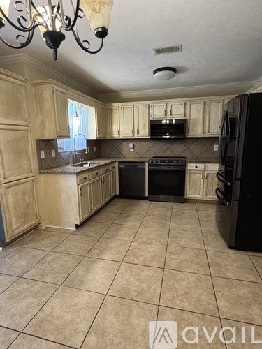 A kitchen with wooden cabinets and black appliances.