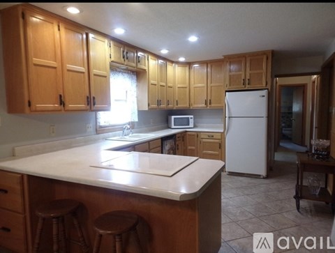 A kitchen with wooden cabinets and a white countertop.