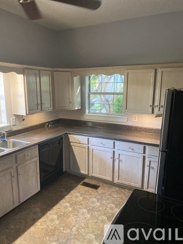 A kitchen with white cabinets and a black stove top.