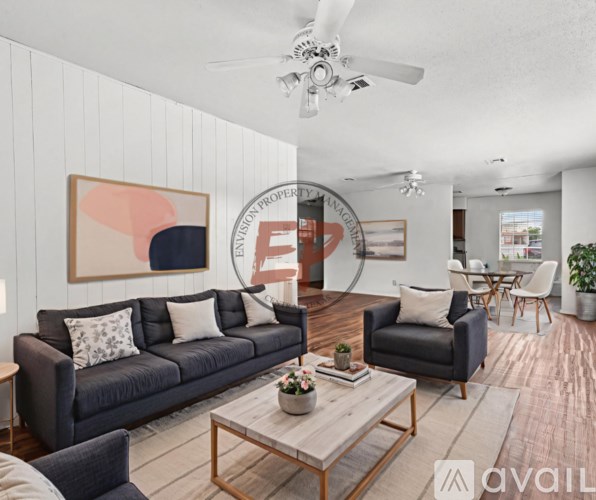 A living room with a grey couch, a coffee table, and a painting on the wall.