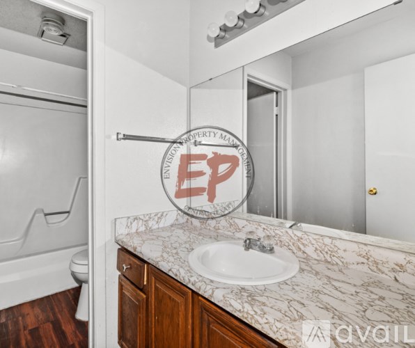 A bathroom with a marble countertop and a mirror with a sticker on it.