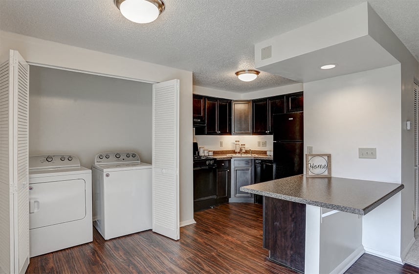A kitchen with a white oven and a black counter.
