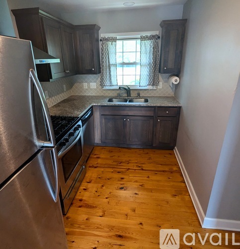 A kitchen with wooden floors and stainless steel appliances.