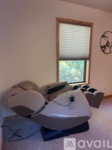 A room with a large window and a wall-mounted speaker.