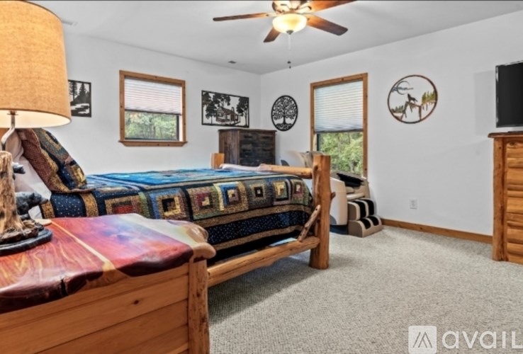 A bedroom with a bed, dresser, and a ceiling fan.