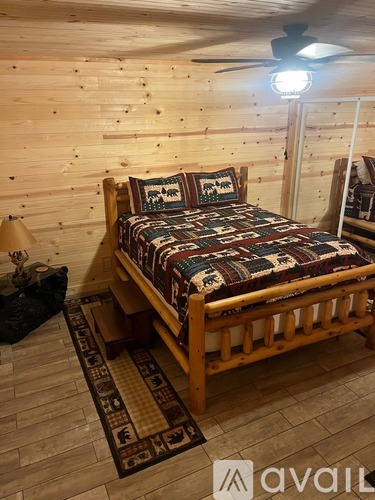 A bedroom with a bed and a ceiling fan.