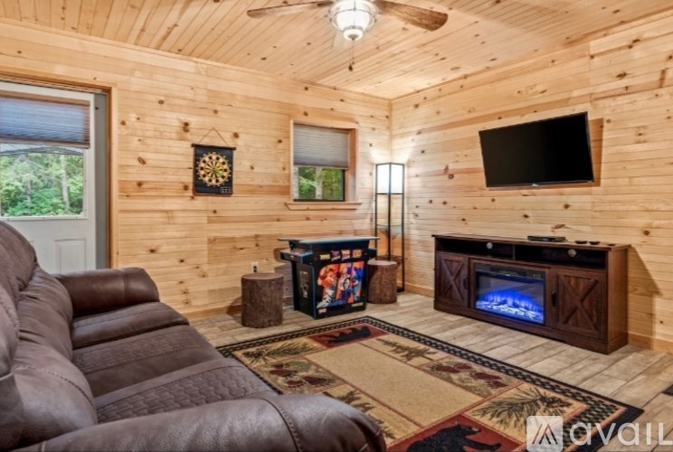 A living room with a brown leather couch and a wooden entertainment center.