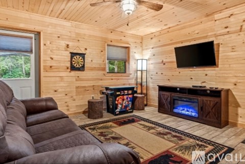 A living room with a brown leather couch and a wooden entertainment center.