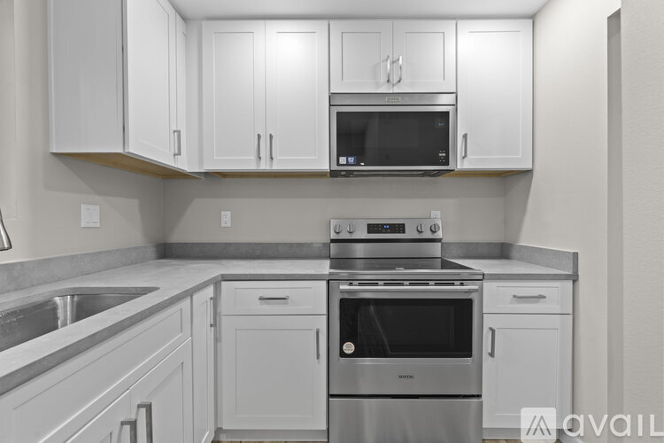 A kitchen with white cabinets and stainless steel appliances.