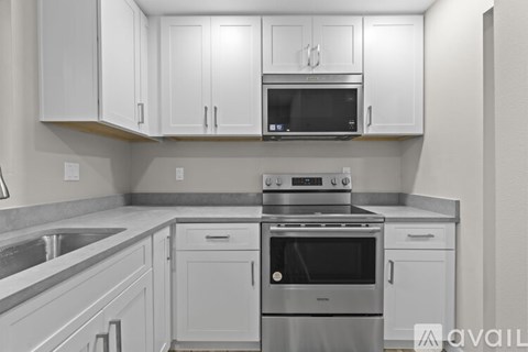 A kitchen with white cabinets and stainless steel appliances.