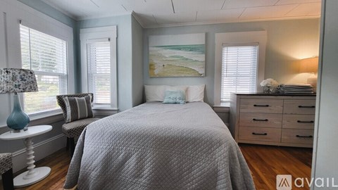 A bedroom with a bed, dresser, and window.