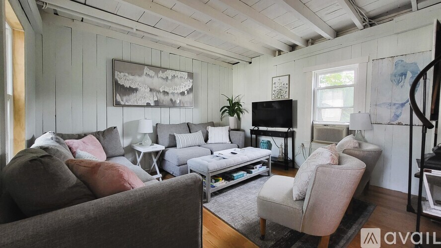 A living room with a grey couch and a television.
