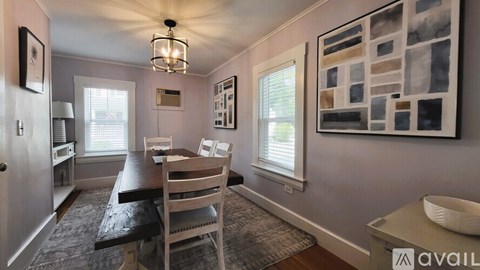 A dining room with a table and chairs.