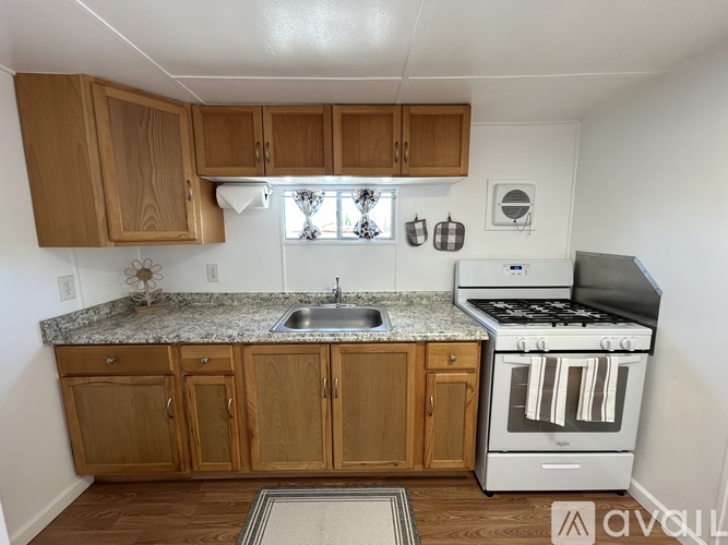 A kitchen with wooden cabinets and a granite countertop.