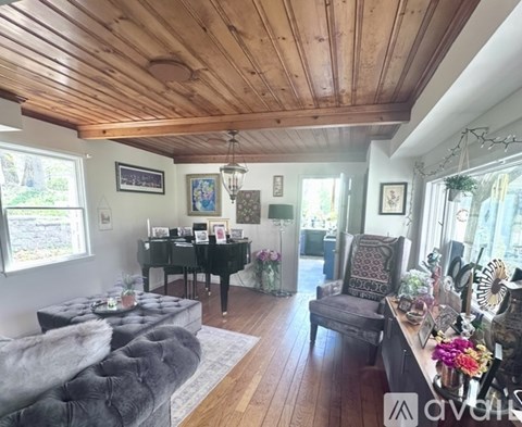 A living room with a grey couch and a wooden ceiling.