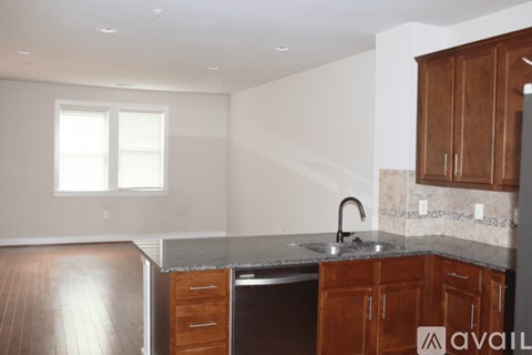 A kitchen with wooden cabinets and a granite countertop.