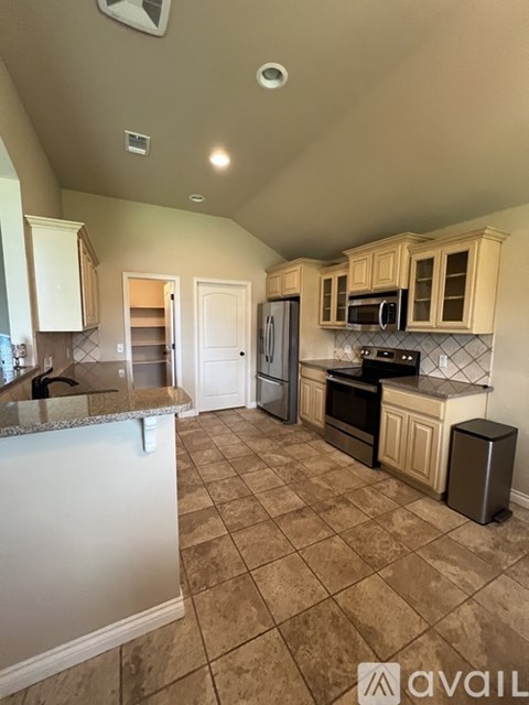 A kitchen with a white counter top and beige cabinets.