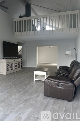 A living room with a white couch and a television.