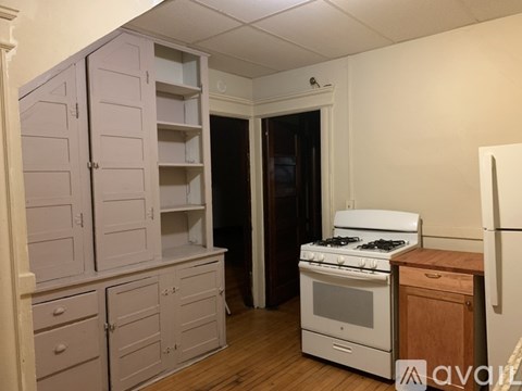 A kitchen with a white stove and wooden counter.