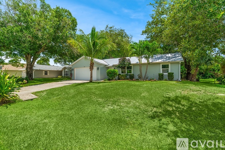 A house with a lawn and trees in front of it.