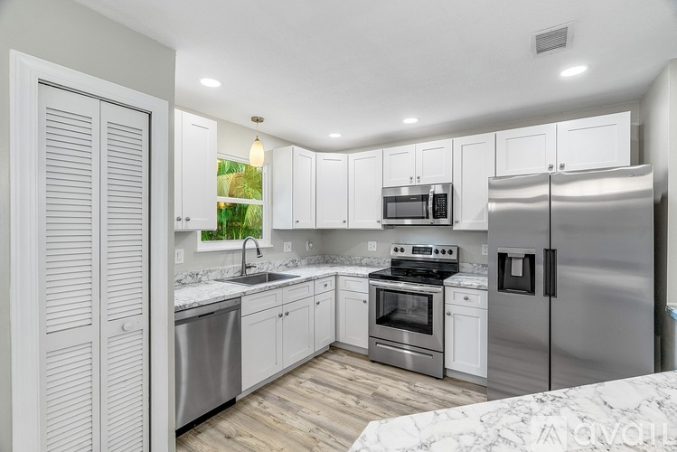 A kitchen with white cabinets and stainless steel appliances.