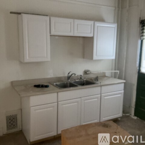A kitchen with white cabinets and a sink.