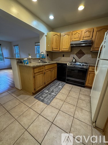 A kitchen with wooden cabinets and a black stove top oven.