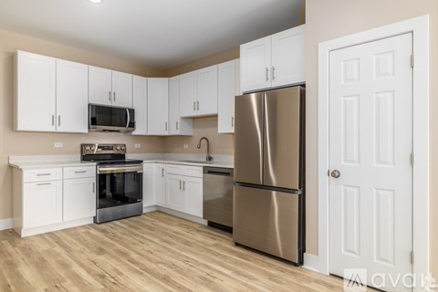 A kitchen with white cabinets and a stainless steel refrigerator.