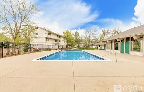 A swimming pool in a backyard surrounded by houses.