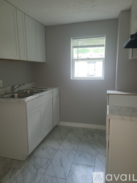 A kitchen with white cabinets and a marble countertop.