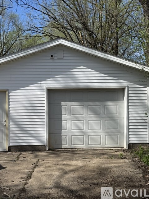 A white garage door is closed and the garage is attached to a house.